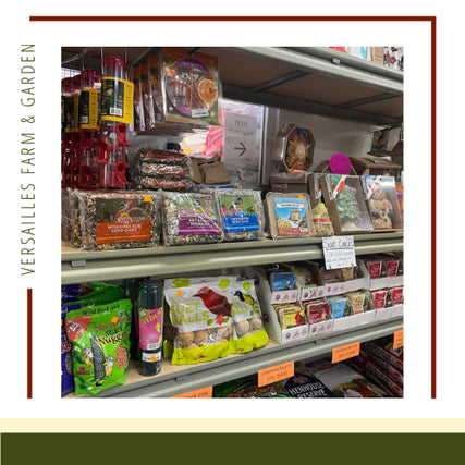Wild BirdShelves displaying a variety of bird seeds and animal feed at Versailles Farm & Garden. Packages are colorful and neatly stacked, creating an inviting and vibrant atmosphere.